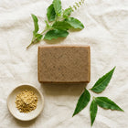 Nivam Neem & Tulsi soap bar flat-lay with neem and tulsi on linen