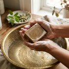 Nivam Neem & Tulsi soap bar lathering in hands over a brass basin