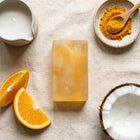 Nivam Turmeric & Coconut Milk soap bar flat-lay with turmeric and coconut on linen